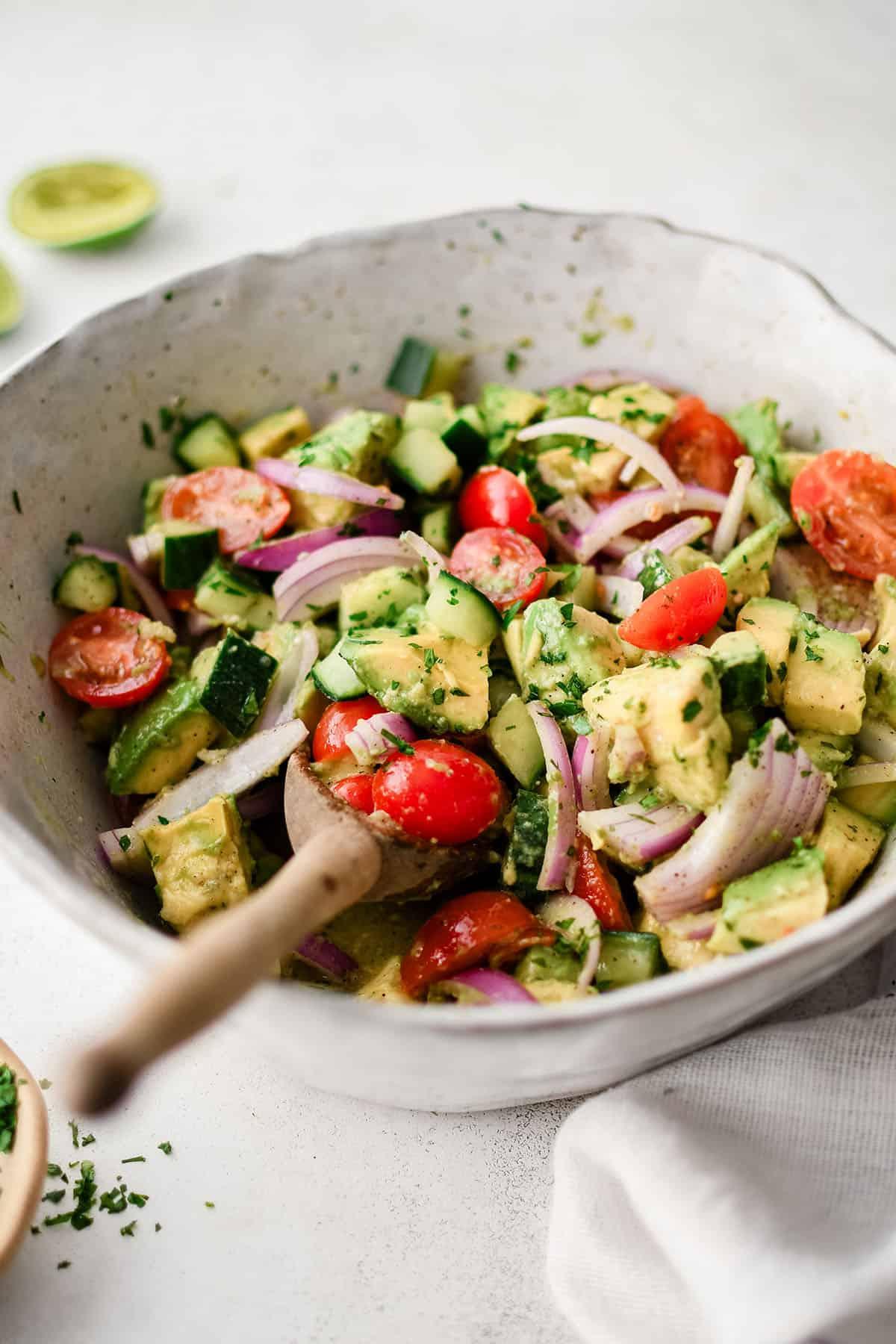 Insalata di Avocado 2 Insalata di avocado con pomodori e cipolle in una ciotola