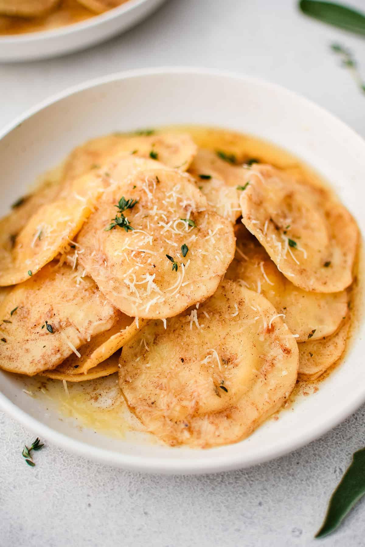 Ravioli con salsa al burro nocciola e aglio in una ciotola bianca