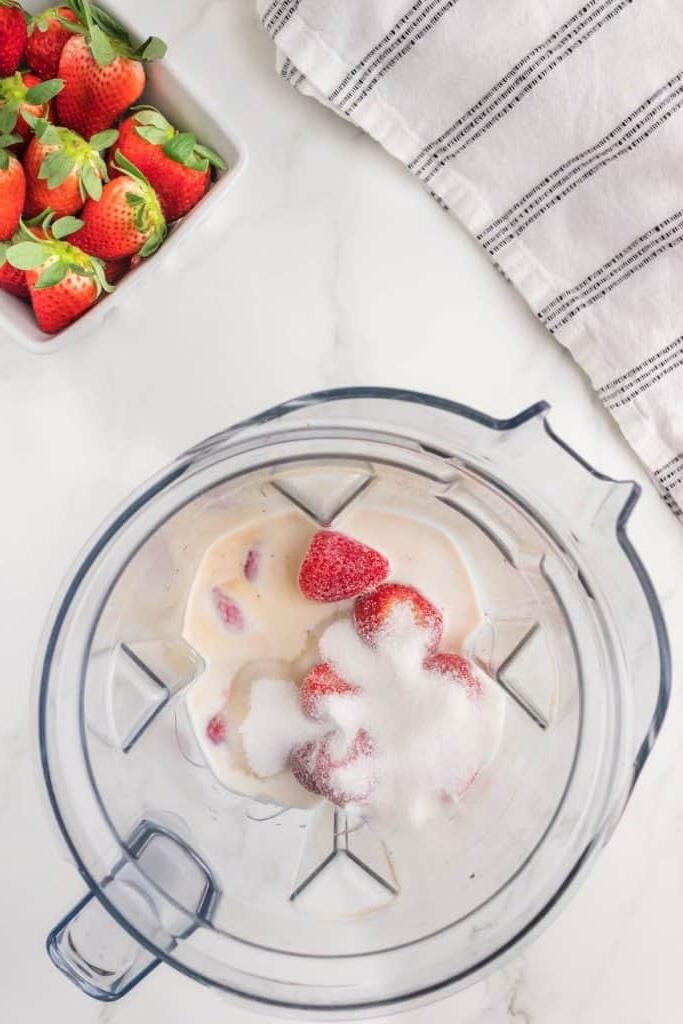 Ingredienti per il gelato alla fragola senza gelatiera in un frullatore