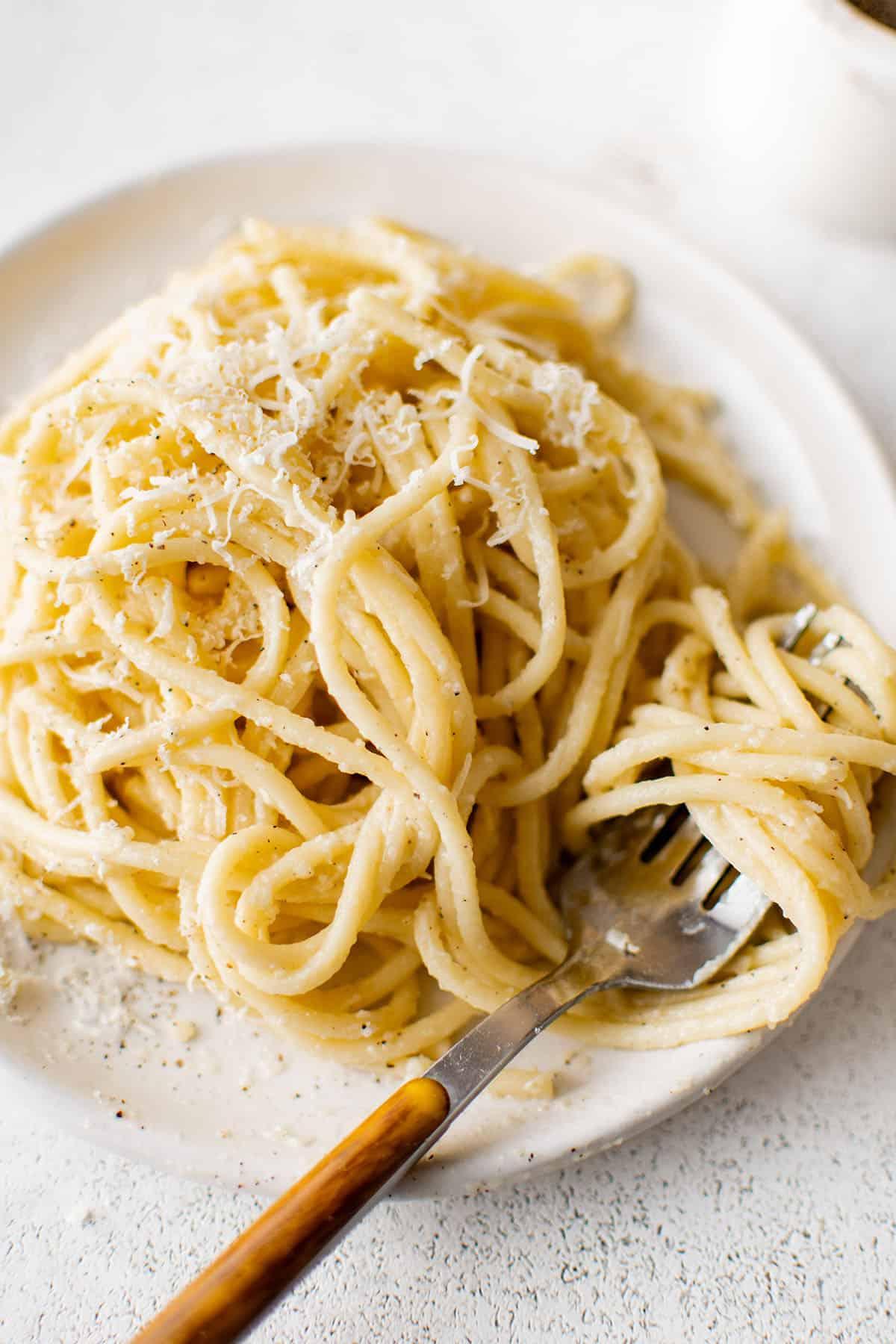 Cacio e Pepe servito in un piatto, con Pecorino grattugiato e pepe fresco in superficie