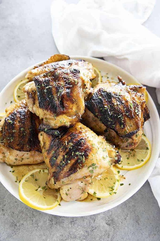 cosce di pollo alla griglia su un piatto bianco