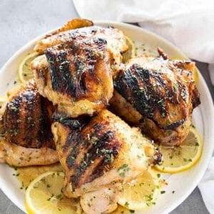 cosce di pollo alla griglia su piatto bianco