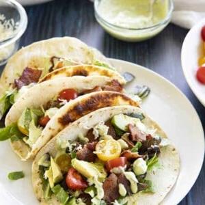 tre tacos blt su un piatto bianco