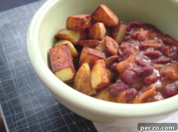 A comforting plate of cooked beans and diced potatoes, ready for a simple, satisfying meal.