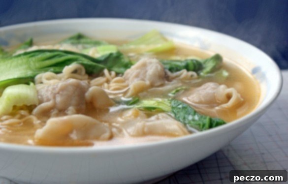 A beautifully composed flat lay of a steaming bowl of homemade wonton soup, with fresh ingredients like bok choy and scallions visible, evoking warmth and comfort.