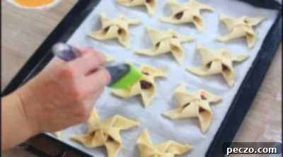 Brushing puff pastry pinwheels with egg wash