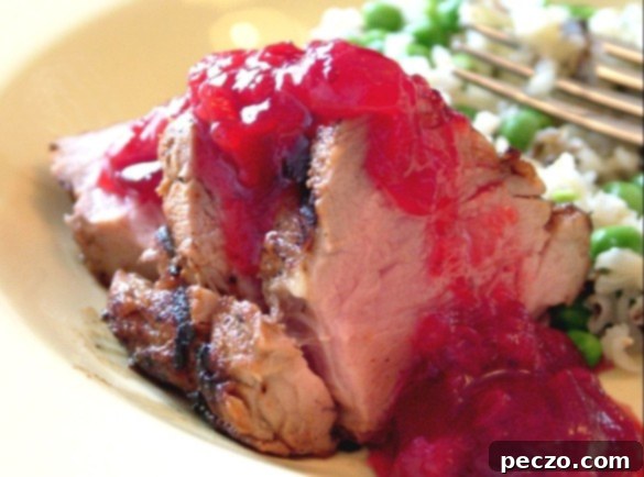 Grilled pork tenderloin with cranberry rhubarb sauce and a side of rice and peas