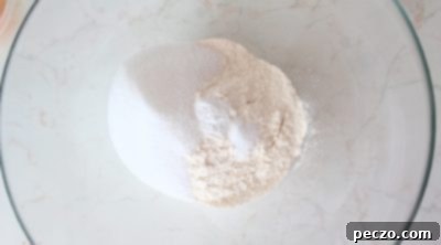 Dry cake ingredients being whisked together in a bowl