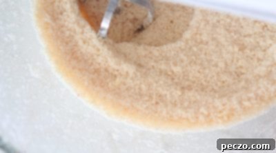 Softened butter being mixed into dry ingredients for cake batter