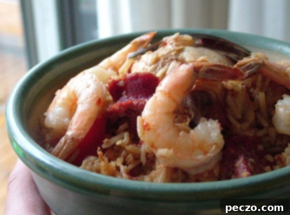 A steaming bowl of delicious homemade Jambalaya, garnished with fresh herbs.