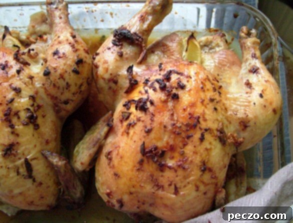 A golden-brown garlic lemon roast chicken, perfectly cooked, resting on a serving platter with lemon slices and herbs.