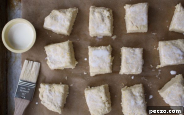 A batch of warm Meyer Lemon Scones cooling on a wire rack, dusted with powdered sugar.