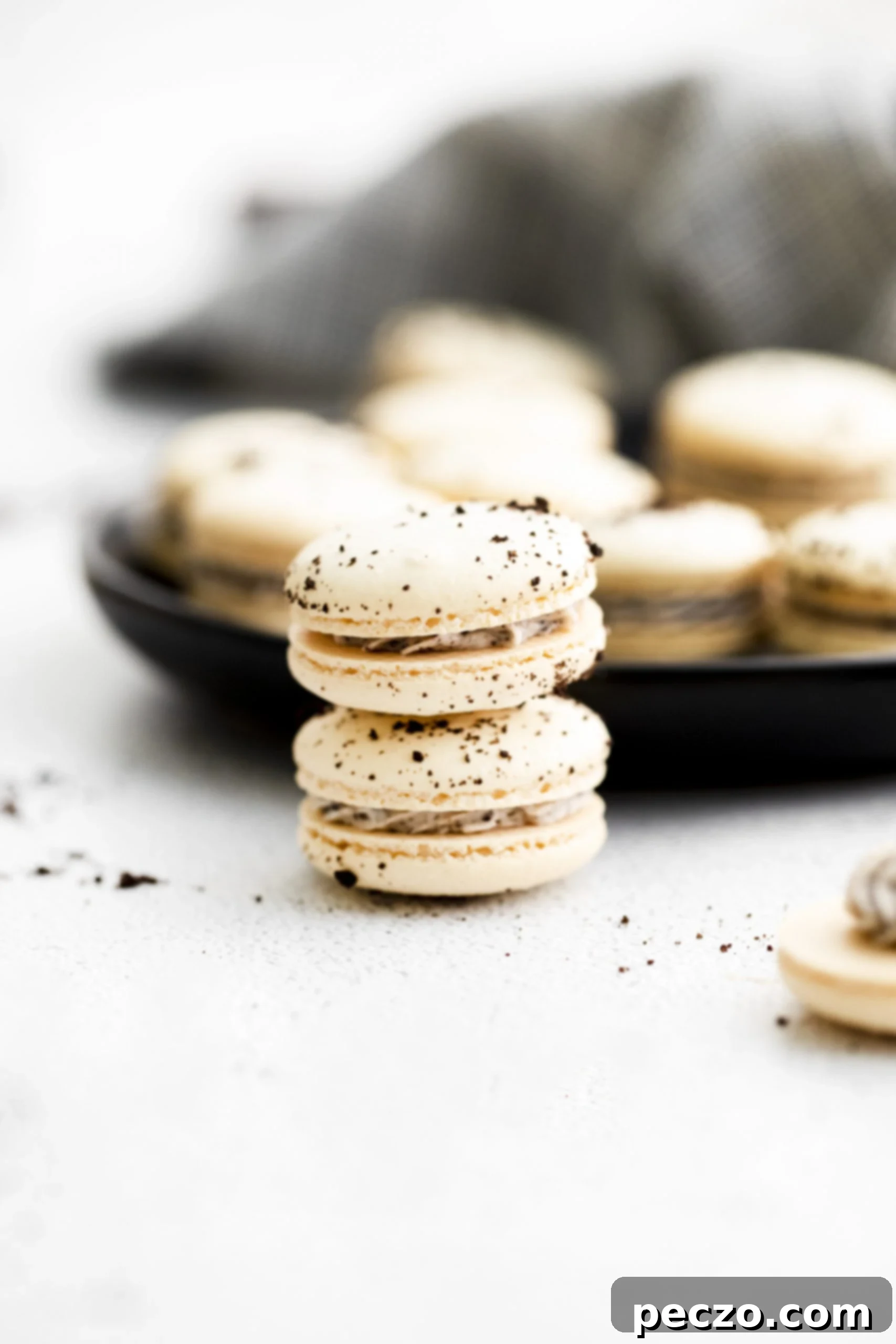 Close-up of freshly piped Oreo macaron batter on parchment paper, ready for resting and baking.