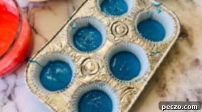 Layering blue cupcake batter into paper liners