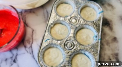 Layering white cupcake batter on top of blue batter