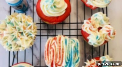 Decorating patriotic cupcakes with white frosting and red and blue sprinkles