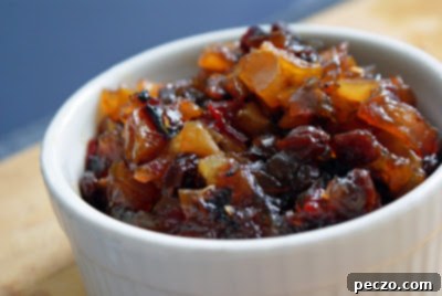 Close-up of golden homemade pear chutney in a rustic dish, showing its rich texture.