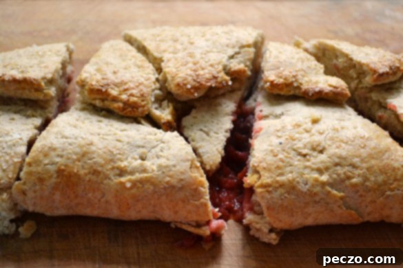 Freshly baked strawberry rhubarb slab scones, golden brown and inviting, ready to be cut and served.