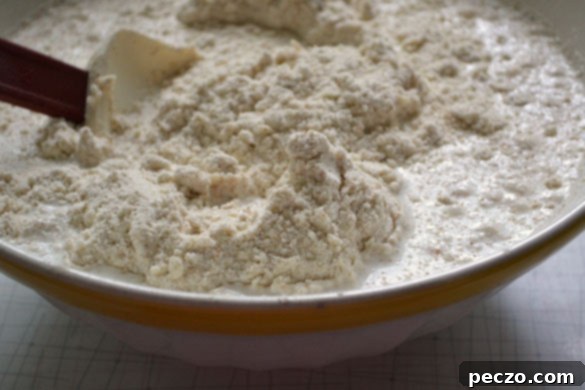 A bowl of cream, potentially soured, ready to be incorporated into scone dough for a richer texture.