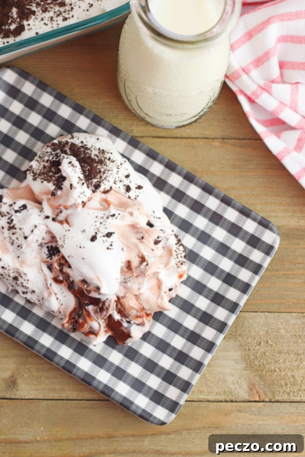 Image of Oreo lasagne layered in a checkered plate next to a glass of milk