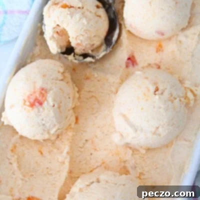 A few balls of peach ice cream in an ice cream container