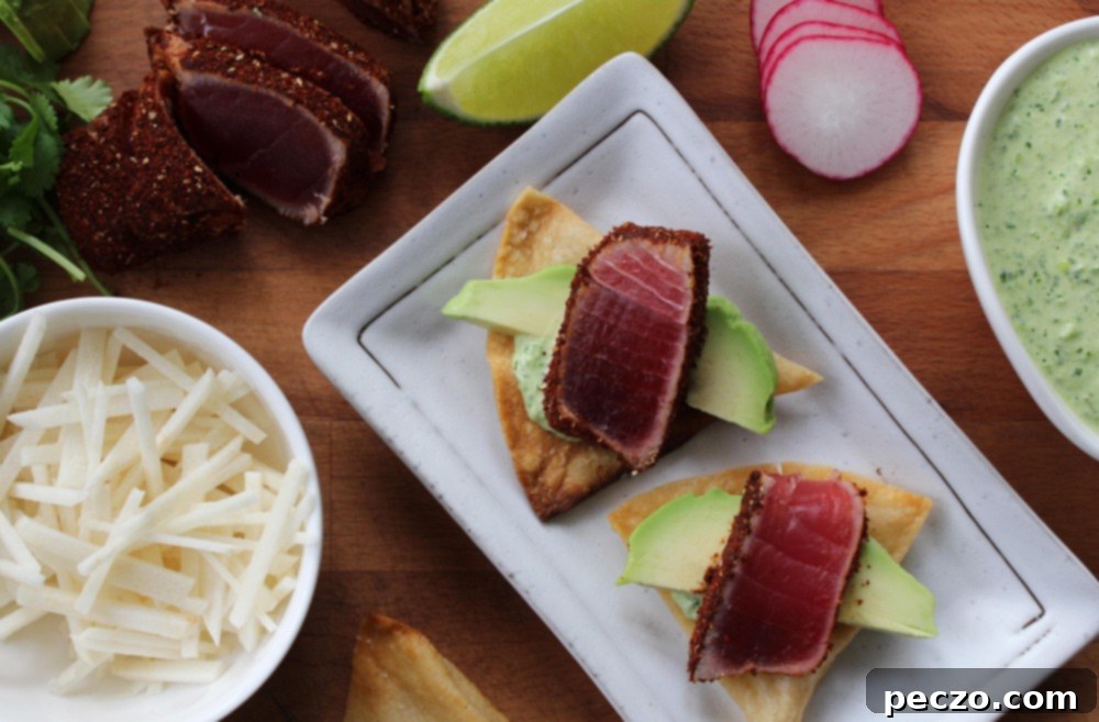 Assembled tuna tostadas with various fresh toppings like avocado, radish, and cilantro