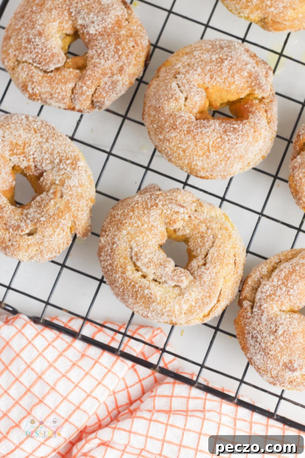 Air fryer donuts on a cooling rack next to a checkered napkin