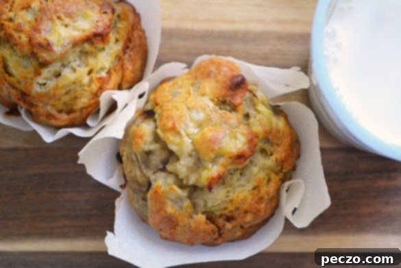Freshly baked golden-brown honey banana muffins with a sprinkle of sugar on top, presented on a cooling rack.