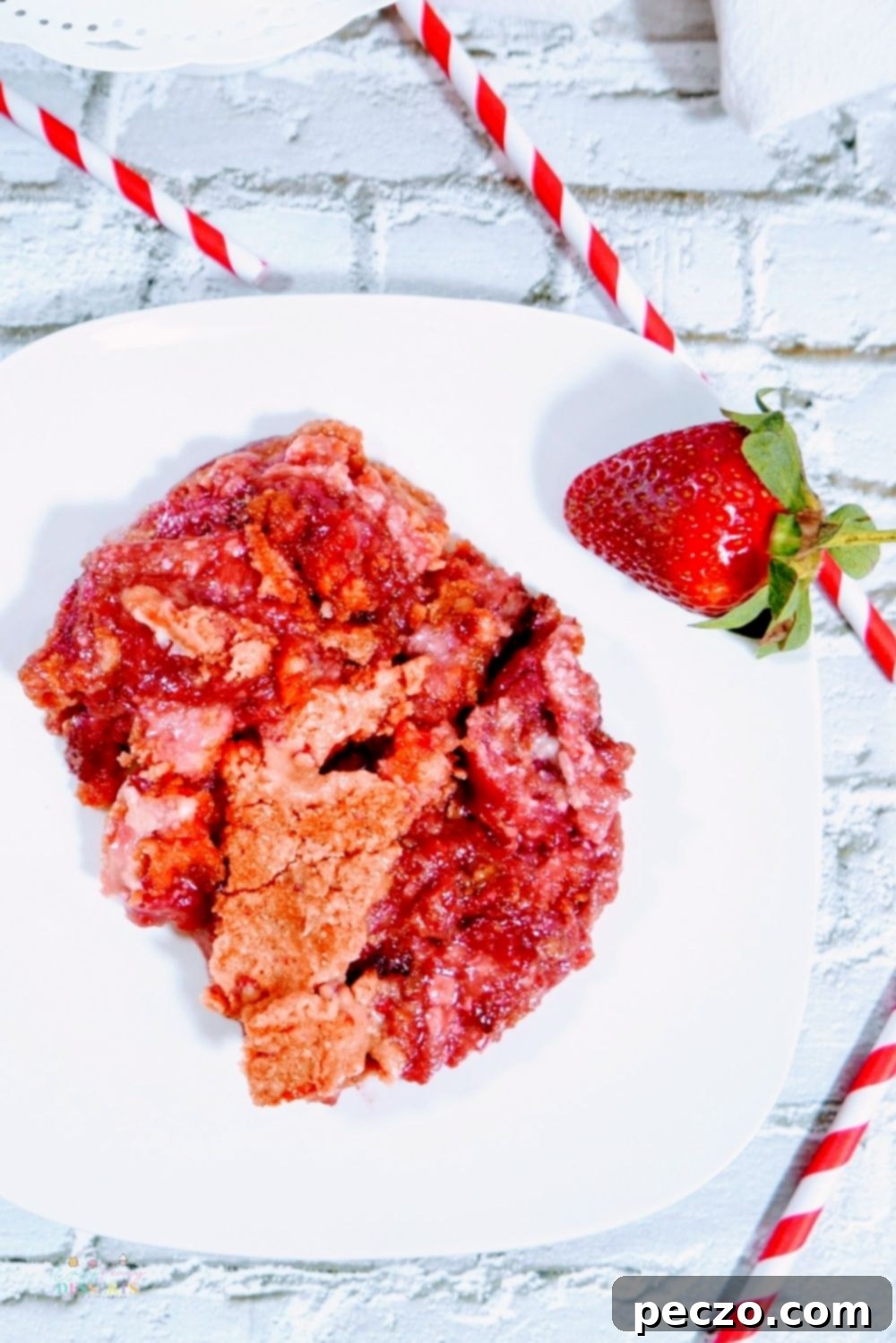 Image of strawberry crumble recipe in a white serving plate, with a spoon