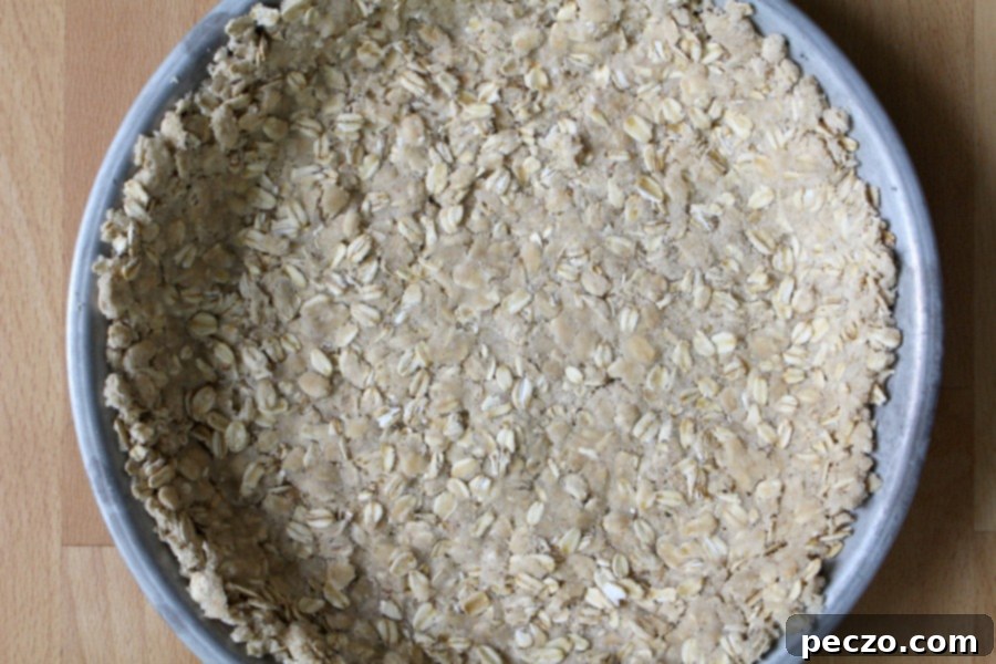 Close-up of a golden brown, textured oatmeal cookie pie crust in a pie plate