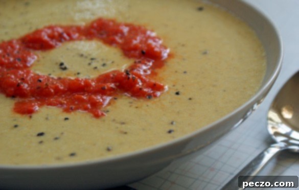 A vibrant, delicious-looking bowl of cauliflower soup, garnished beautifully.
