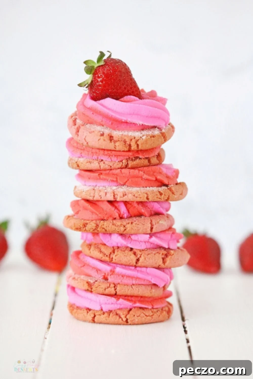 A charming stack of homemade strawberry cream cheese cookies, each topped with a fresh, vibrant strawberry slice