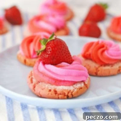 Image of strawberry cream cookies decorated with cream cheese frosting and fresh strawberries, on a serving plate
