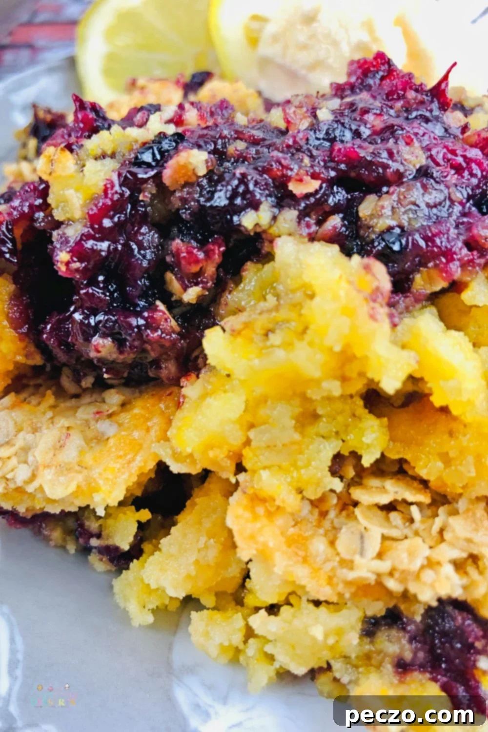 Zoomed in image of blackberry dump cobbler with lemon slices for garnish