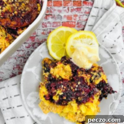 Blackberry dump cake on a white serving plate, next to a baking dish filled with the same cobbler