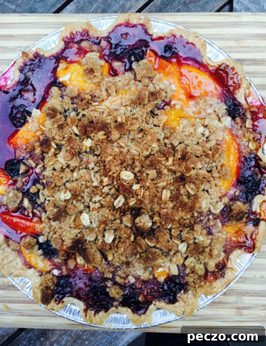 Close-up of a stone fruit crumble pie with berries