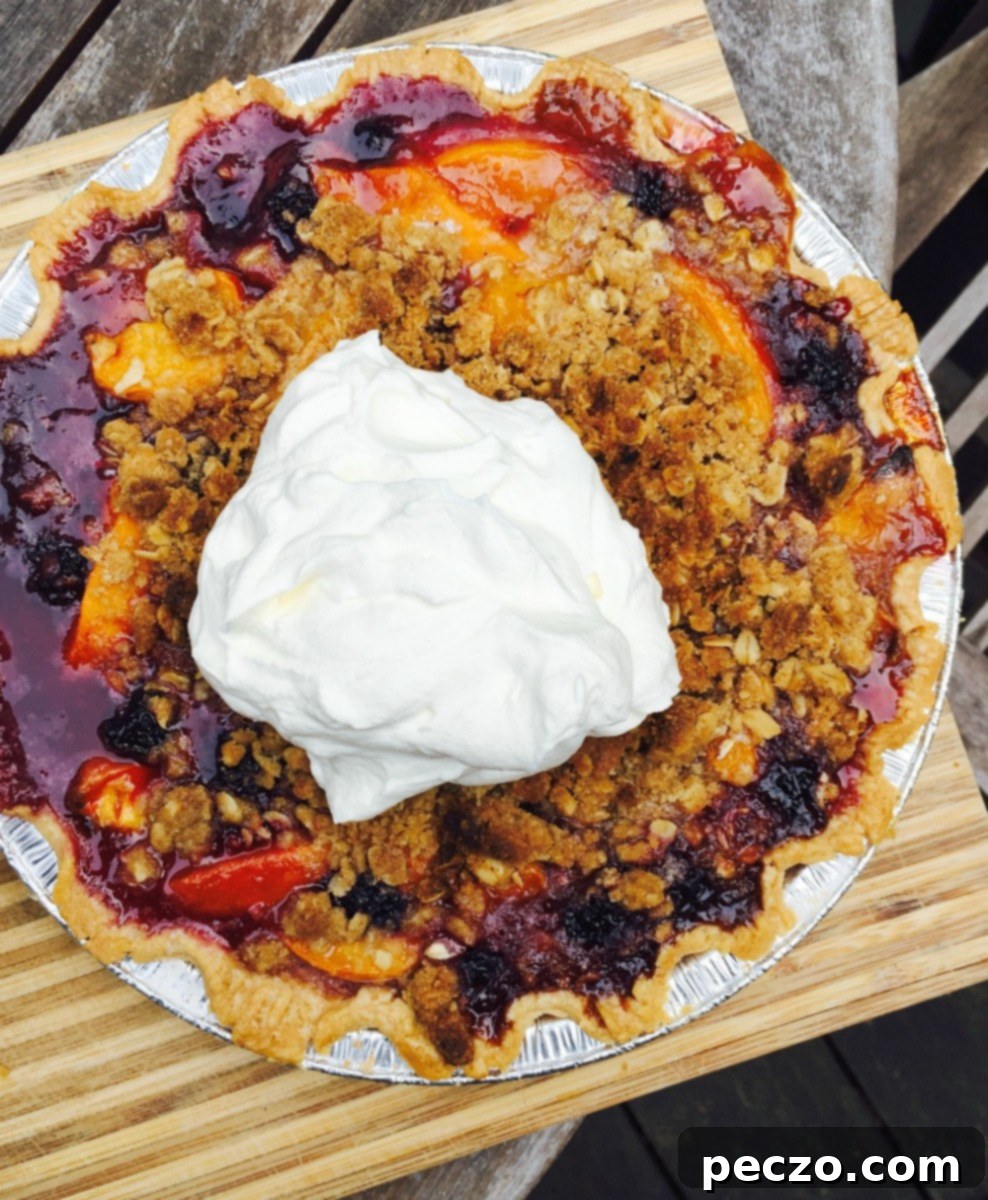 Stone fruit crumble pie on a rustic wooden table