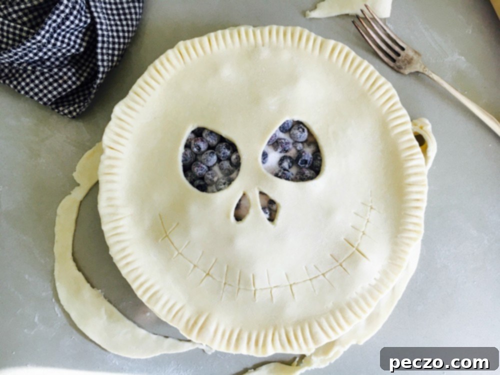 A baked Jack Skellington pie cooling on a wire rack, showcasing the golden-brown crust and intricate face detail.