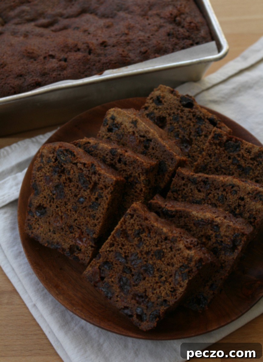 Rich, spiced gingerbread fruitcake adorned with dried fruits, ready for holiday festivities.