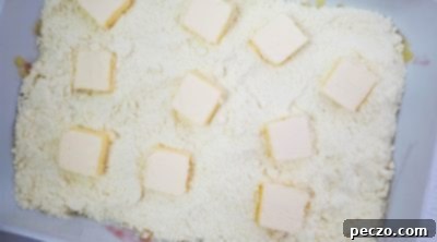 Butter slices arranged on dry cake mix in a baking pan