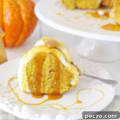 Close up image of a slice of pumpkin bundt cake with buttercream frosting, drizzled with caramel sauce