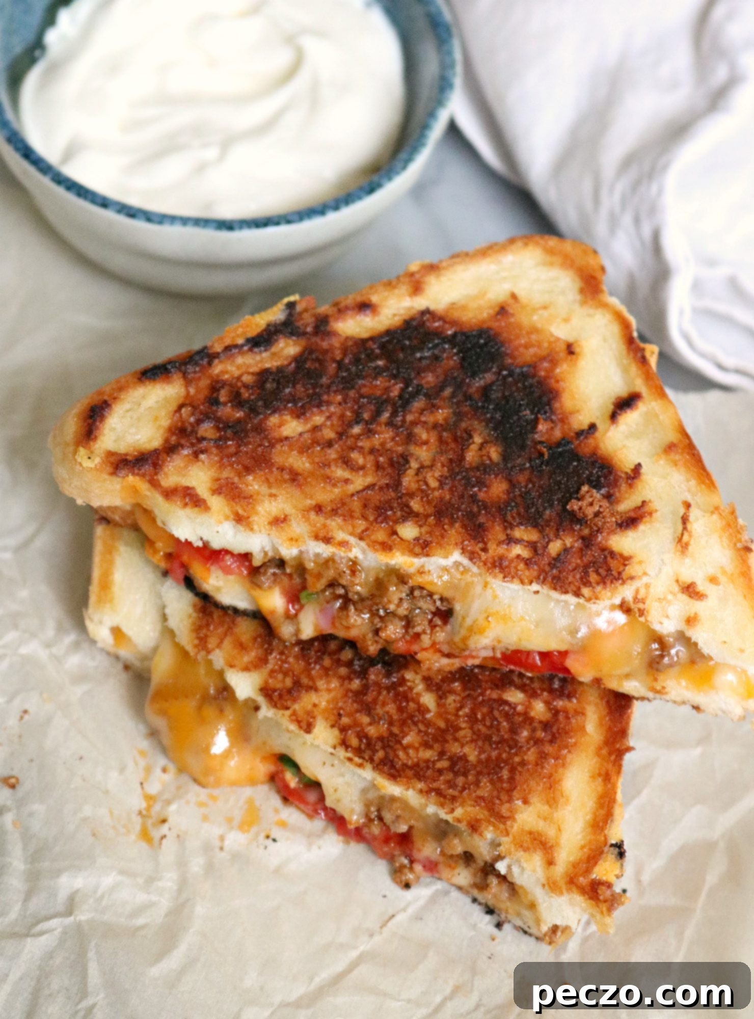 Close-up of a taco grilled cheese sandwich, showcasing the perfectly melted cheese, seasoned beef, and salsa filling between golden-brown, crispy bread slices.