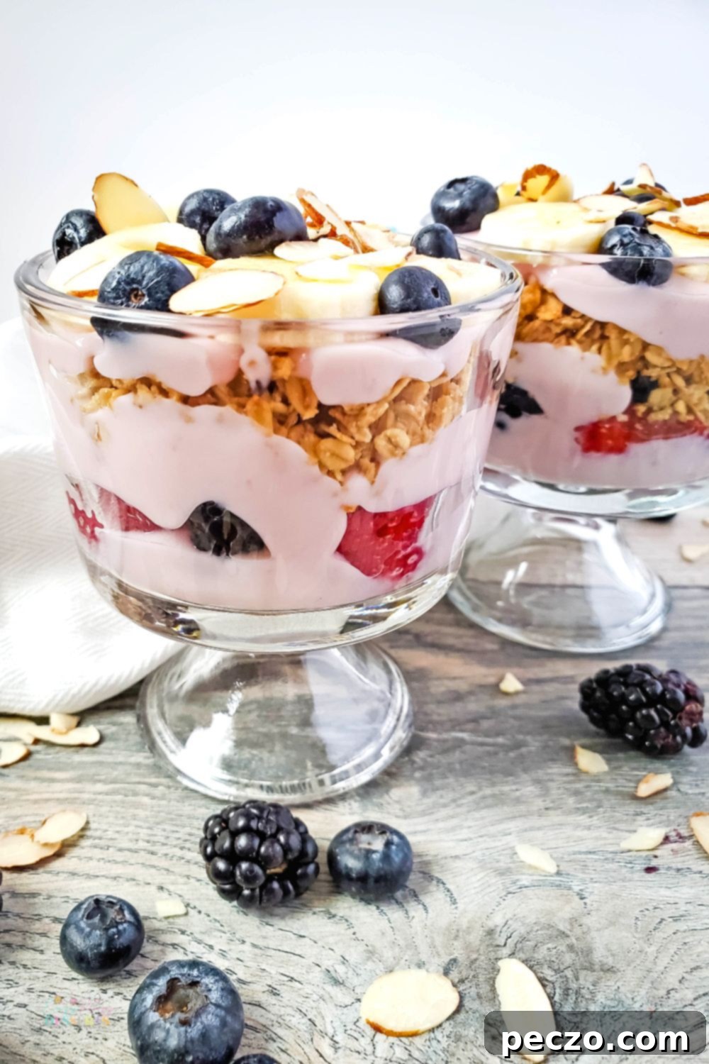 Close up image of light berry trifle in elegant serving cups, showcasing layers of vibrant berries and creamy yogurt.