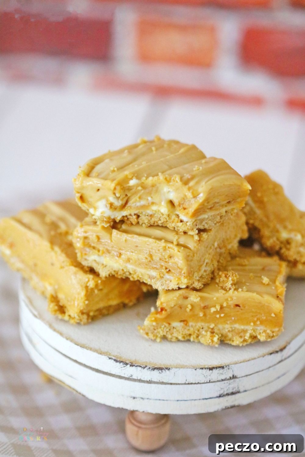 A few individual peanut butter cheesecake bars arranged neatly on a elegant dessert serving plate, highlighting their creamy texture and graham crust.