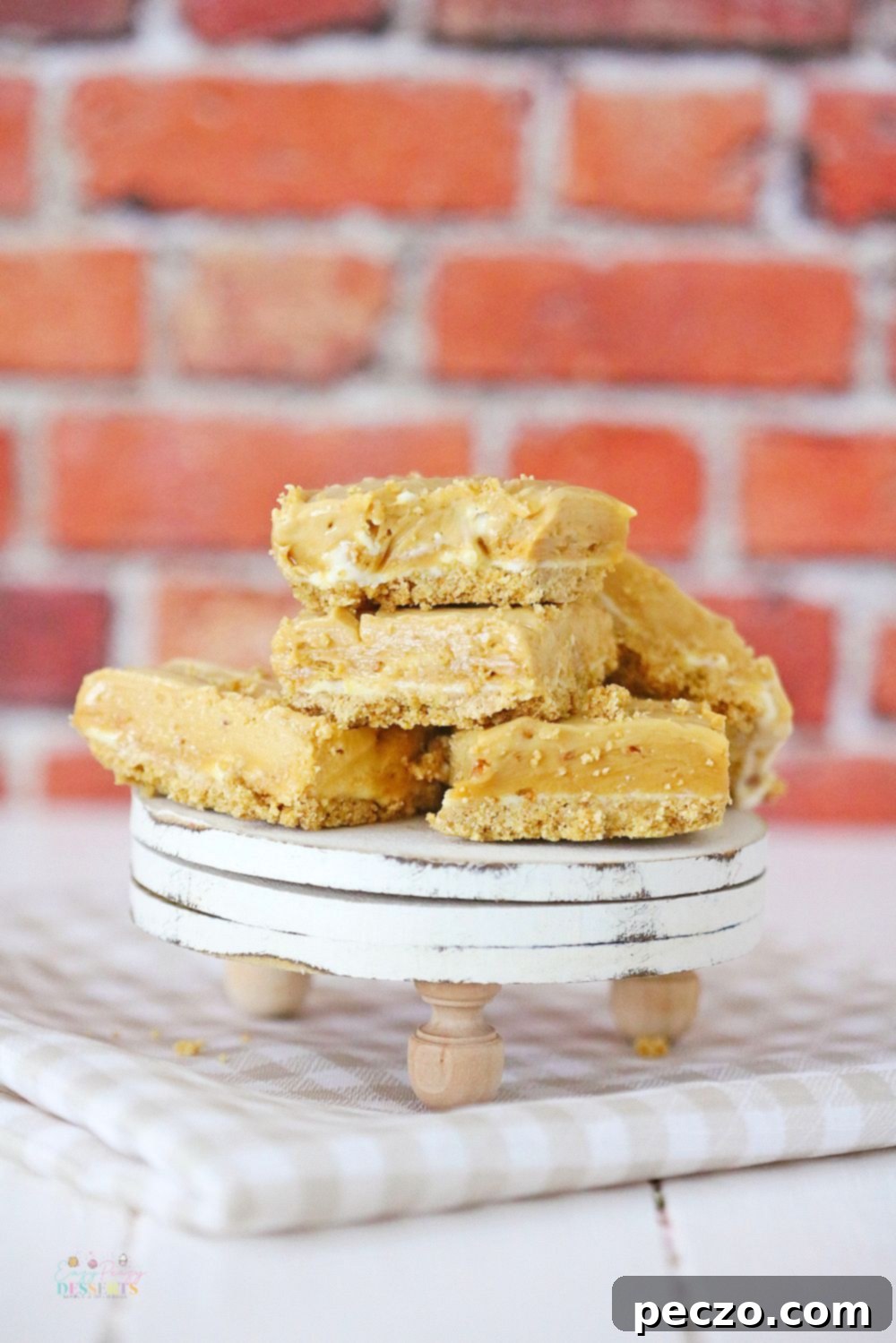A close-up view of several delicious peanut butter fudge with cream cheese and a graham crust bars, beautifully arranged on a dessert plate.
