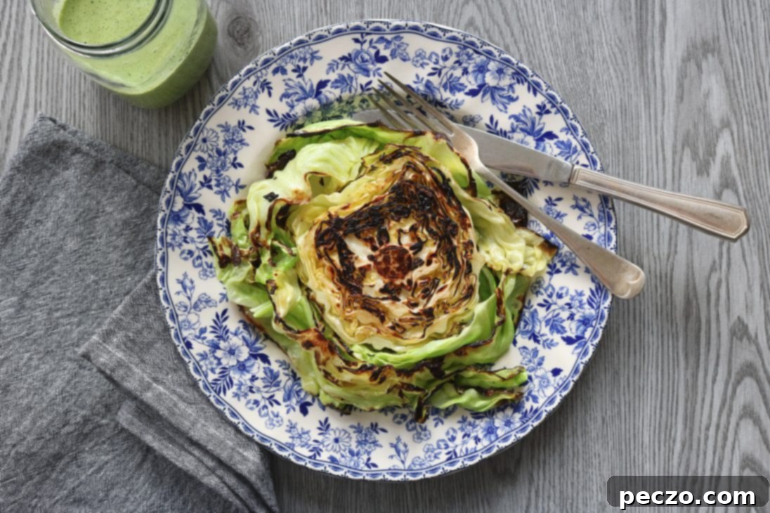 Plated charred cabbage and crispy smashed potatoes, drizzled with jalapeño-garlic-cilantro sauce