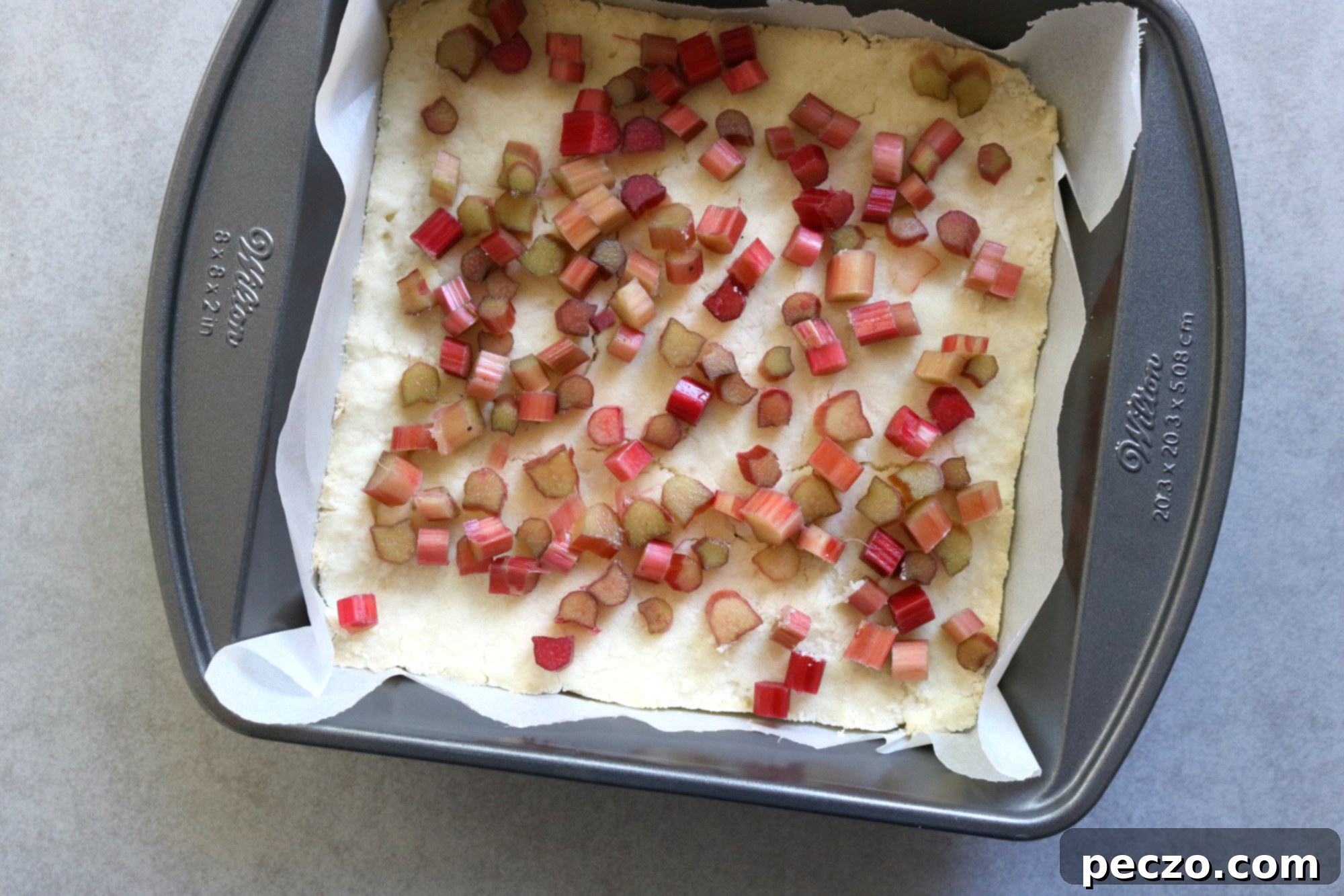 Close-up of small chopped rhubarb pieces, ready for baking.