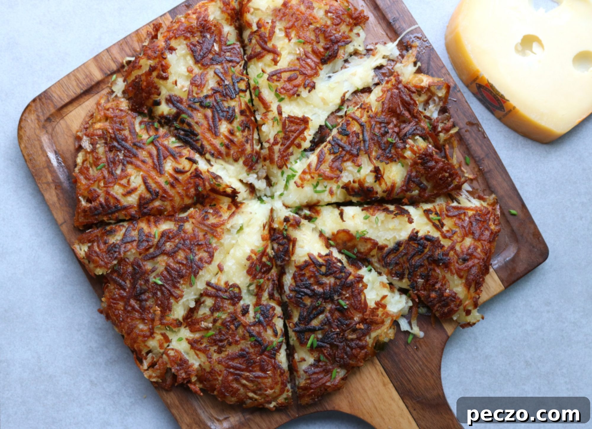 Crispy potato Rösti stuffed with melted Jarlsberg cheese, served on a cutting board.