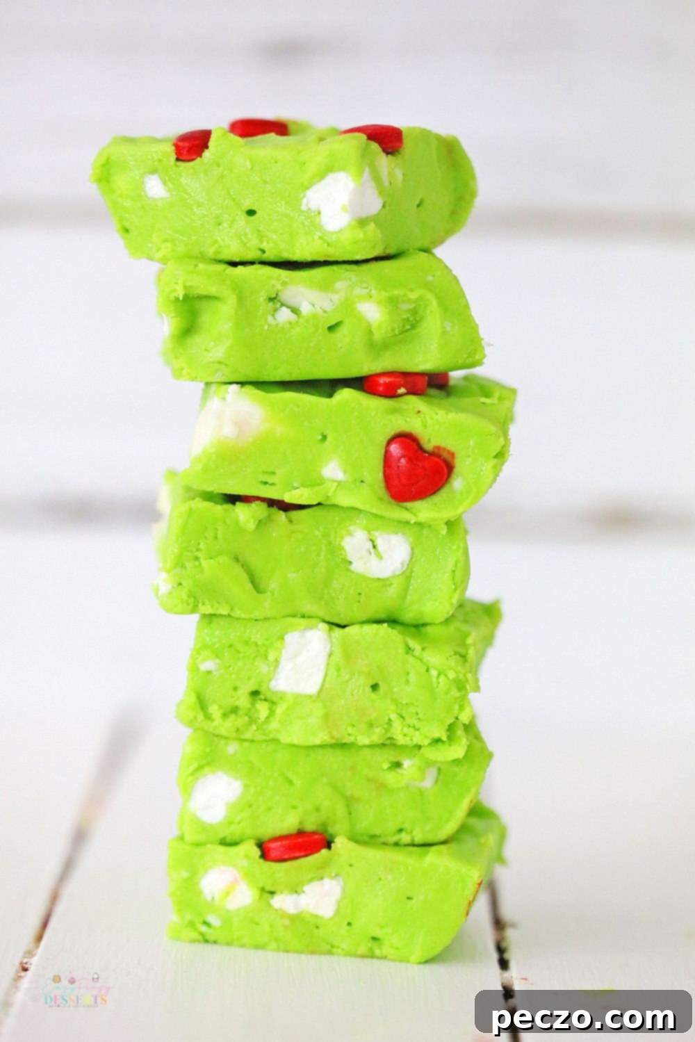 Slices of Grinch fudge displayed in a stack on a wooden table