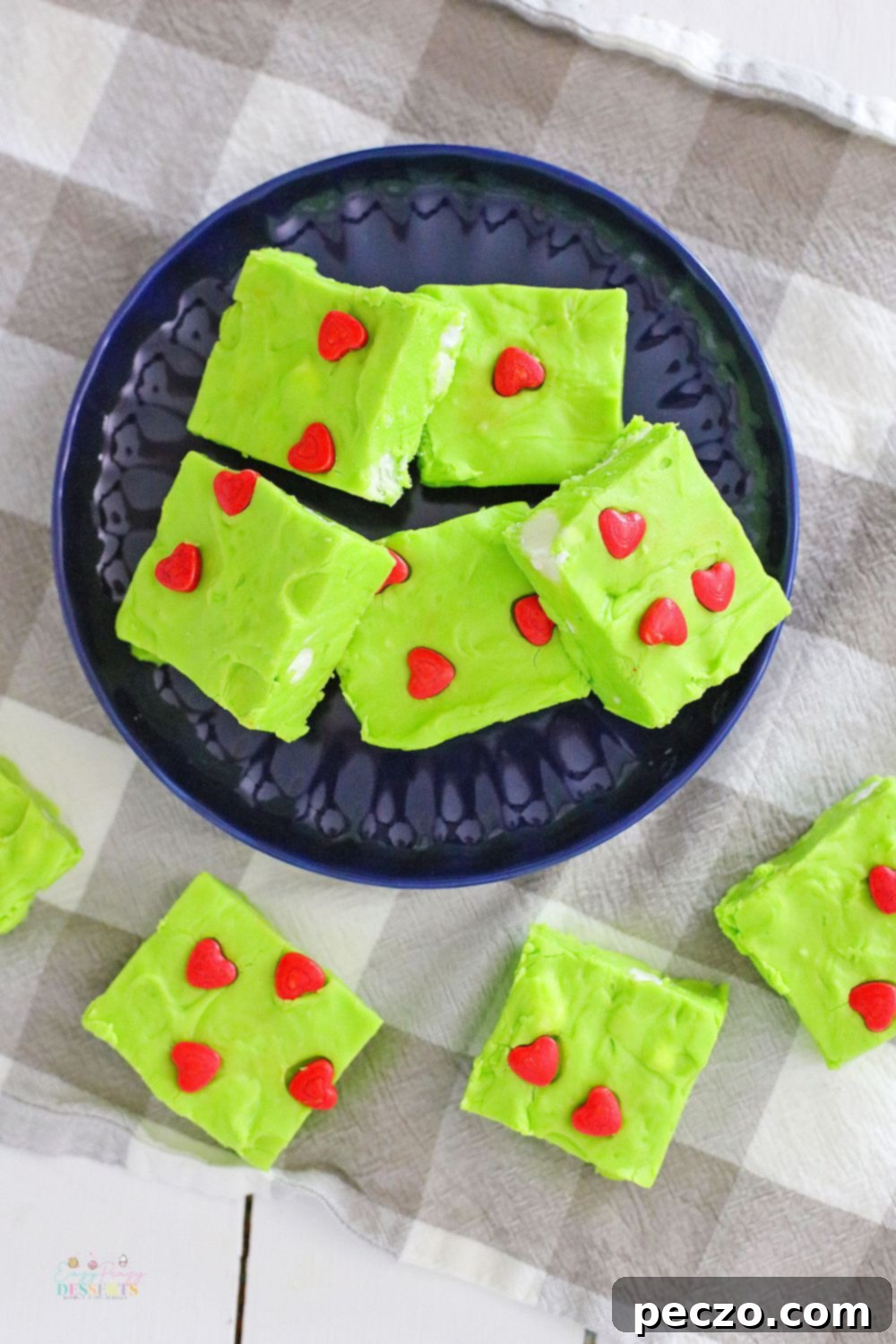 Image of Christmas fudge in green color, decorated with red hearts and white marshmallows